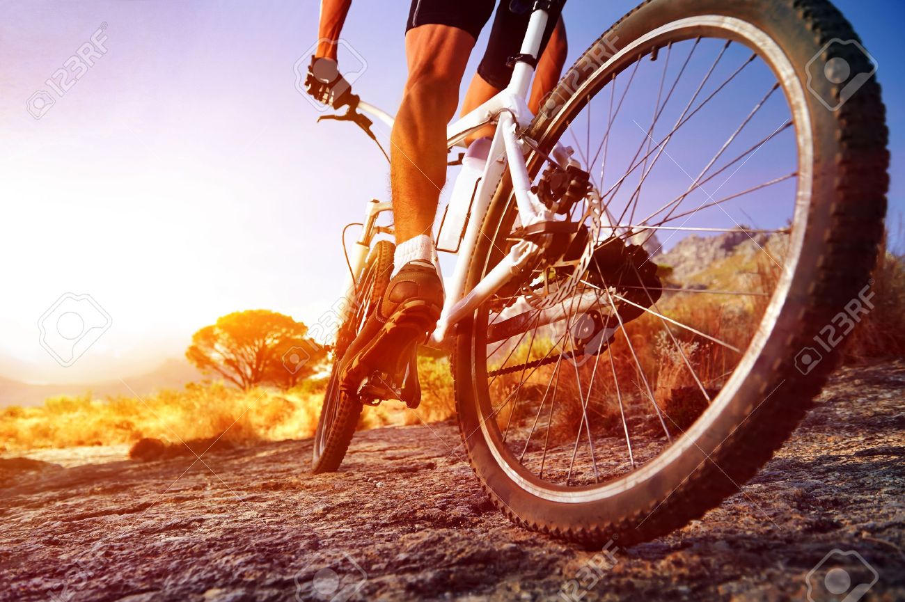low angle view of cyclist riding mountain bike on rocky trail at sunrise - 18911501 low angle view of cyclist riding mountain bike on rocky trail at sunrise - 18911501