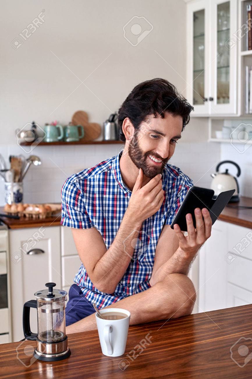 男の家庭の台所でモバイル携帯電話でフランス語を押すフィルター コーヒーを楽しむ の写真素材 画像素材 Image