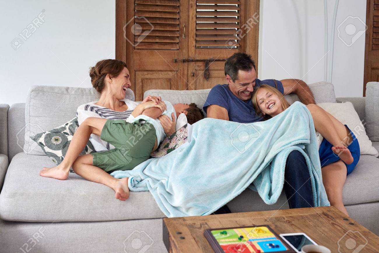 happy excited kids brother and sister jumping and playing with parents on the couch in living room - 49226040 happy excited kids brother and sister jumping and playing with parents on the couch in living room - 49226040