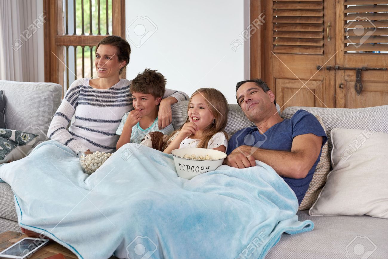 Happy laughing Caucasian family with two children relaxing at home, kids brother and sister watching a movie and having popcorn with parents - 49228329 Happy laughing Caucasian family with two children relaxing at home, kids brother and sister watching a movie and having popcorn with parents - 49228329