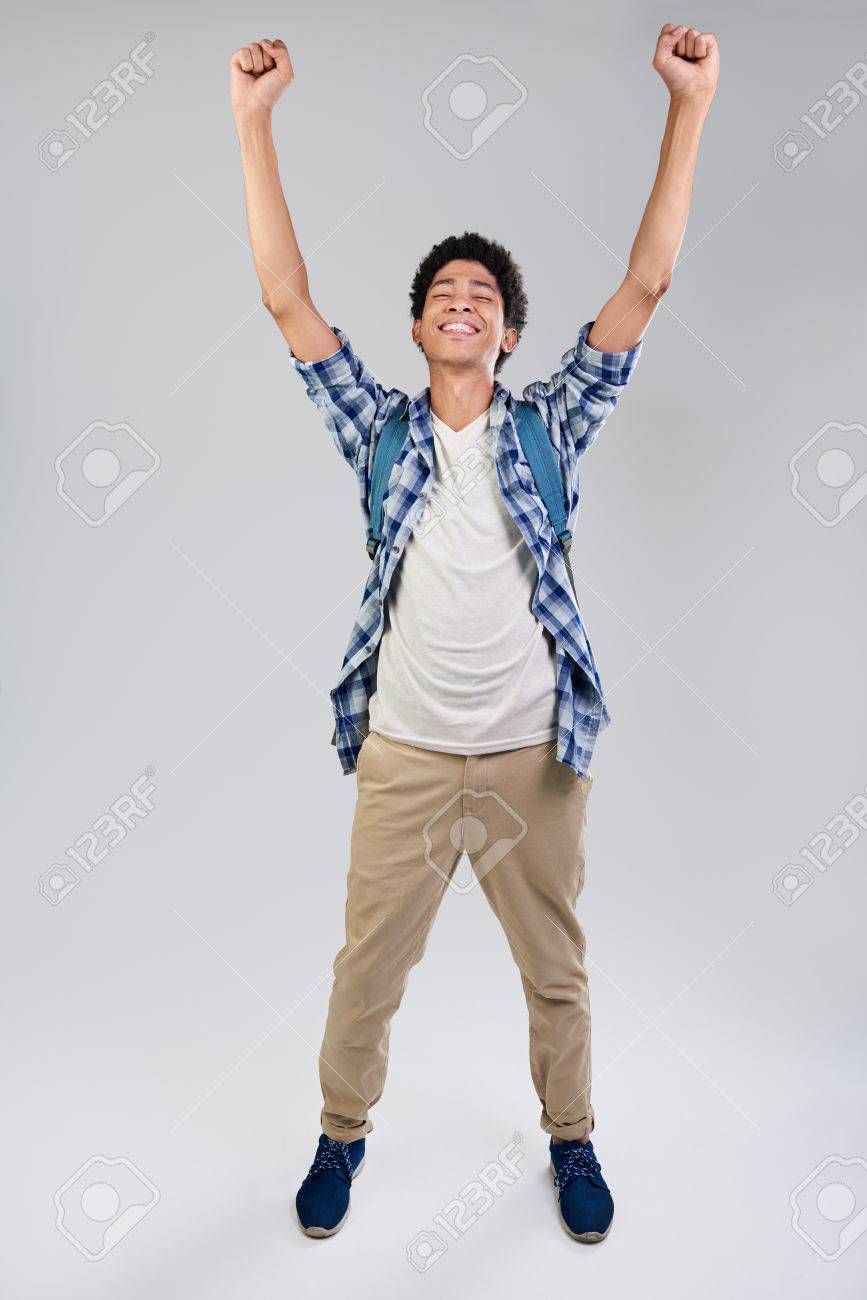 混血若い男の腕の中で大喜びの笑顔発生の孤立した灰色の背景 の写真素材 画像素材 Image