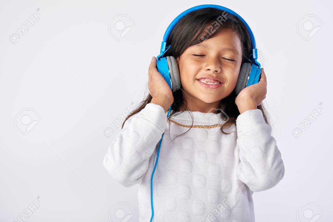 young girl playing her favorite song on headphones isolated in studio - 63979361 young girl playing her favorite song on headphones isolated in studio - 63979361