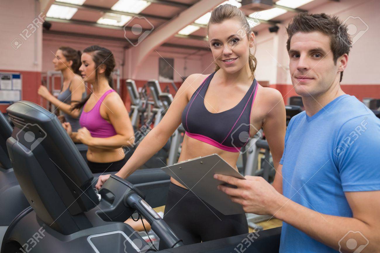 gym instructor and woman in the gym on the treadmill stock photo gym instructor