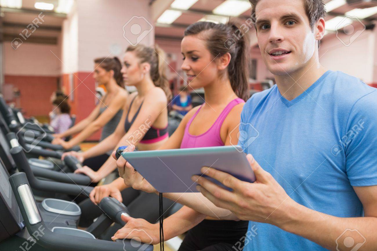 male gym instructor with women on treadmills in gym stock photo gym instructor