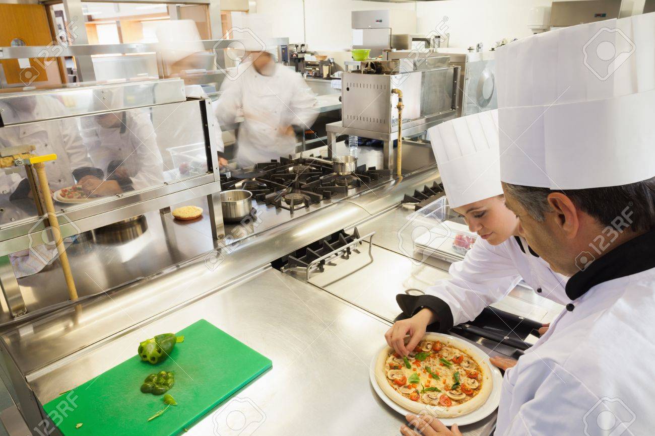 Busy Kitchen cooks preparing pizza in busy kitchen stock photo, picture and Busy Kitchen cooks preparing pizza in busy kitchen stock photo, picture and