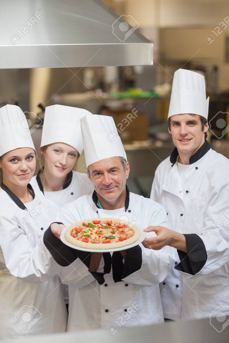 A smiling chef holding a pizza in a take out box Stock Photo - Alamy