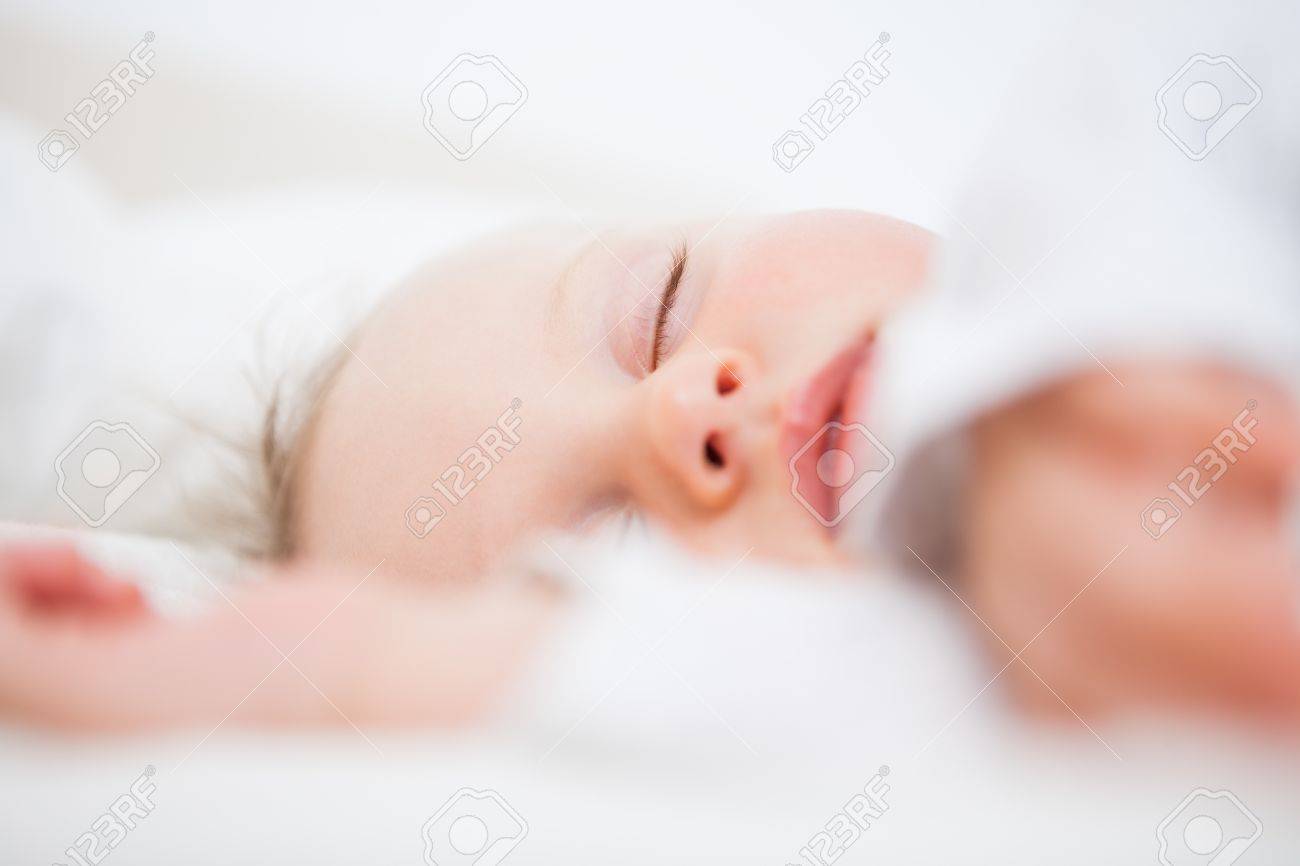 Baby Falling Asleep While Extending Her Arms In A Bedroom