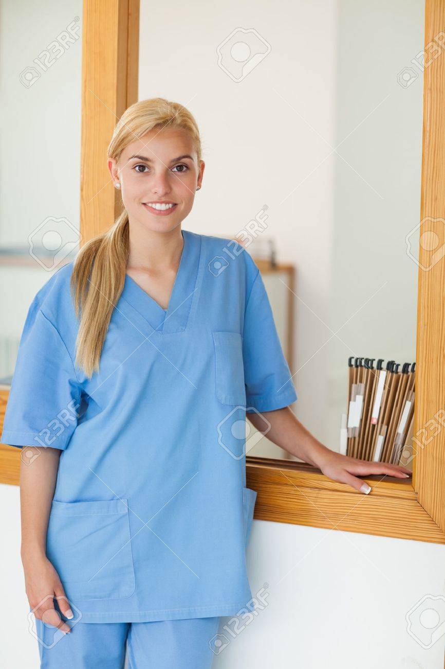 blonde nurse looking at camera in hospital reception stock photo