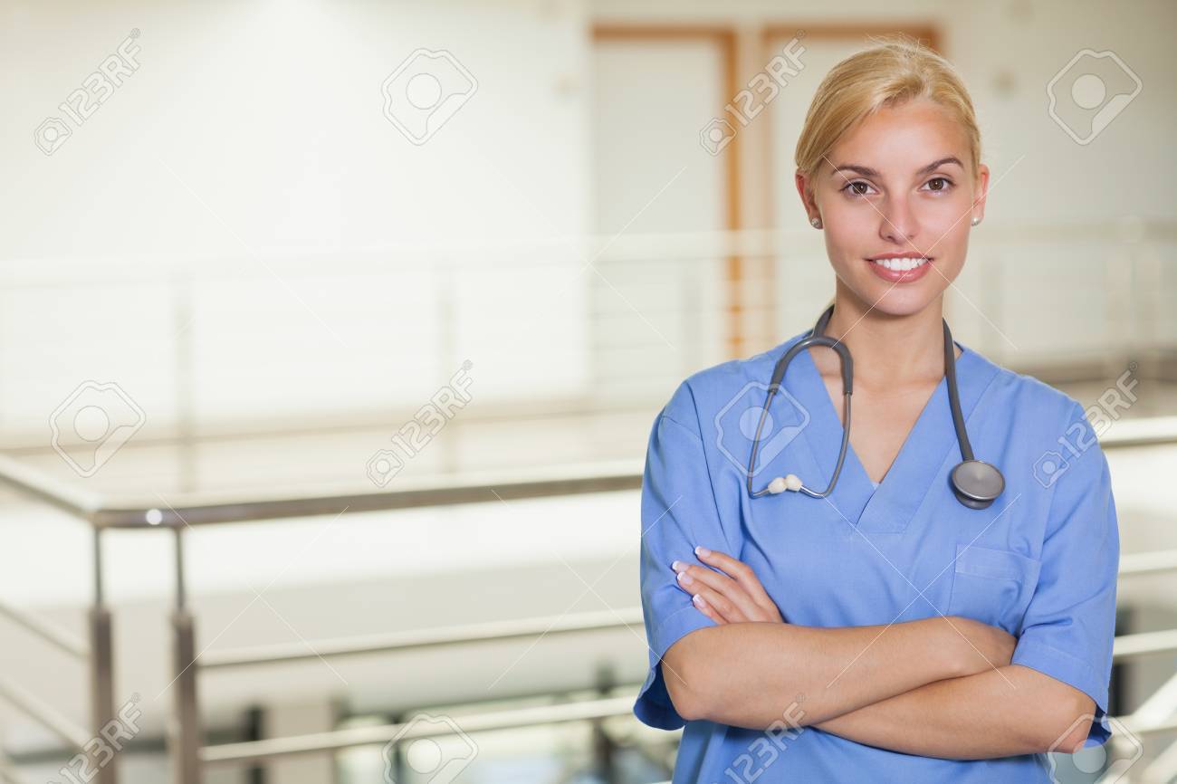 blonde nurse looking at camera with arms crossed in hospital stock