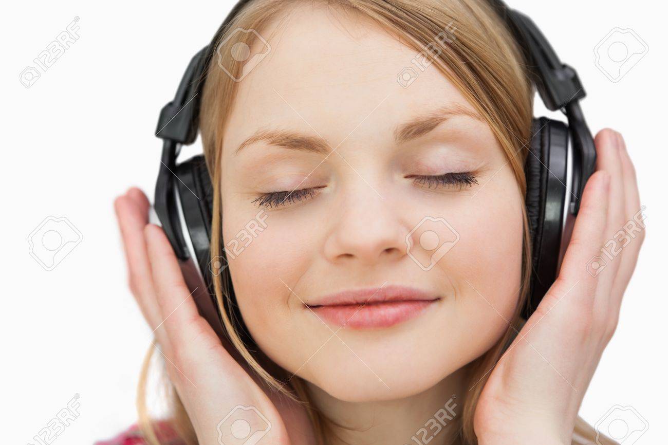 Close up of a woman with headphones against a white background - 16203430 Close up of a woman with headphones against a white background - 16203430