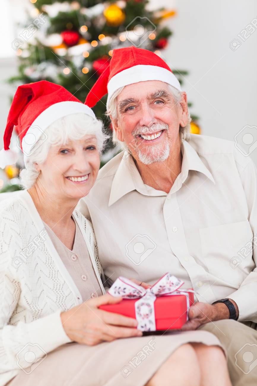Smiling Old Couple Swapping Christmas