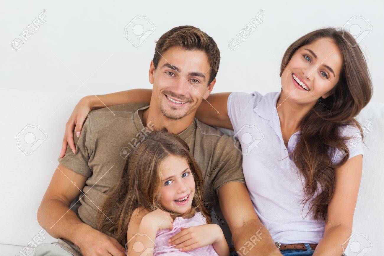 Happy family sitting together on a sofa in the living room - 18121775 Happy family sitting together on a sofa in the living room - 18121775