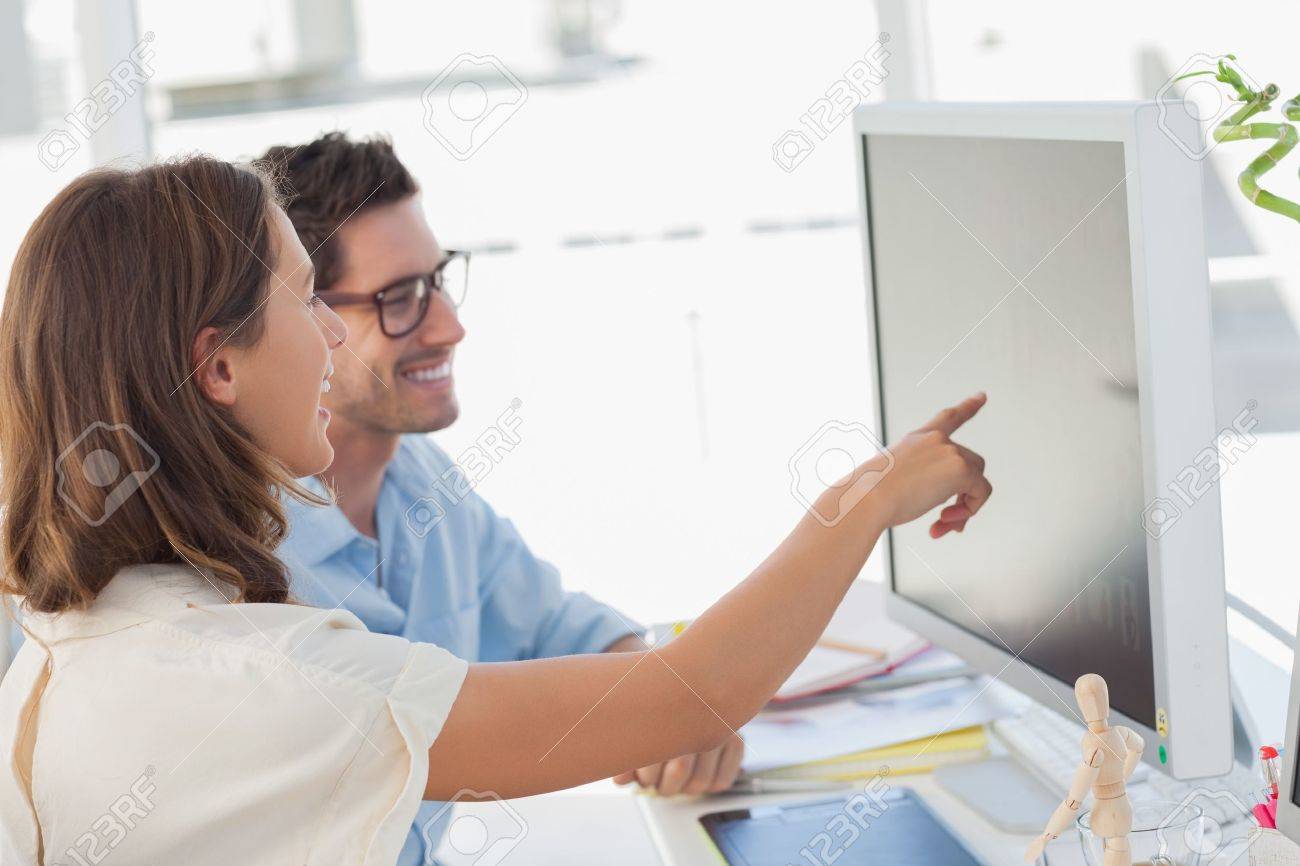 Attractive photo editor pointing at the screen while working with a colleague - 20586337 Attractive photo editor pointing at the screen while working with a colleague - 20586337