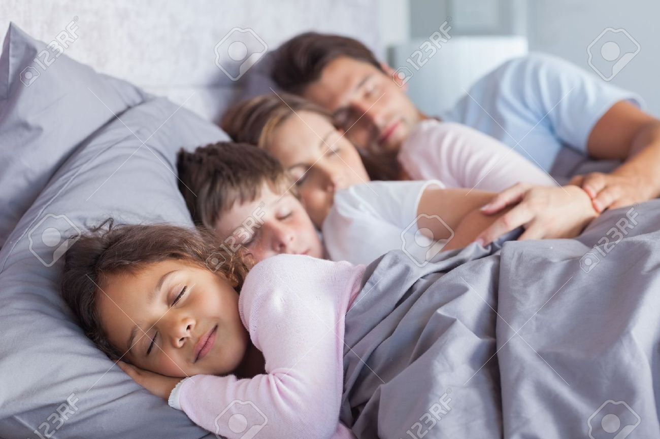 Cute family sleeping together in bed stock photo 20640603