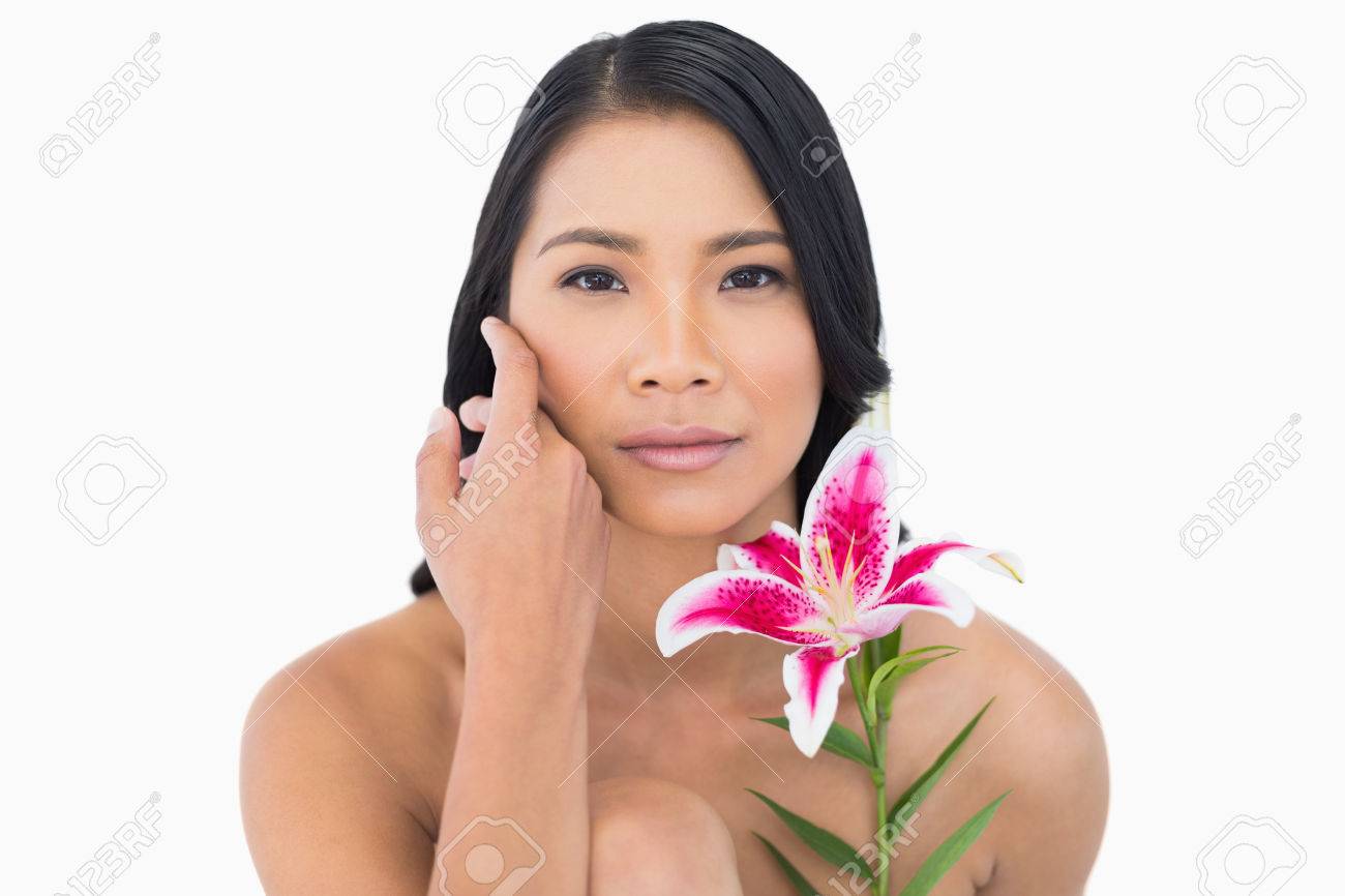 自然な黒髪モデル リリーと白い背景の上に彼女の顔を Caressing の写真素材 画像素材 Image