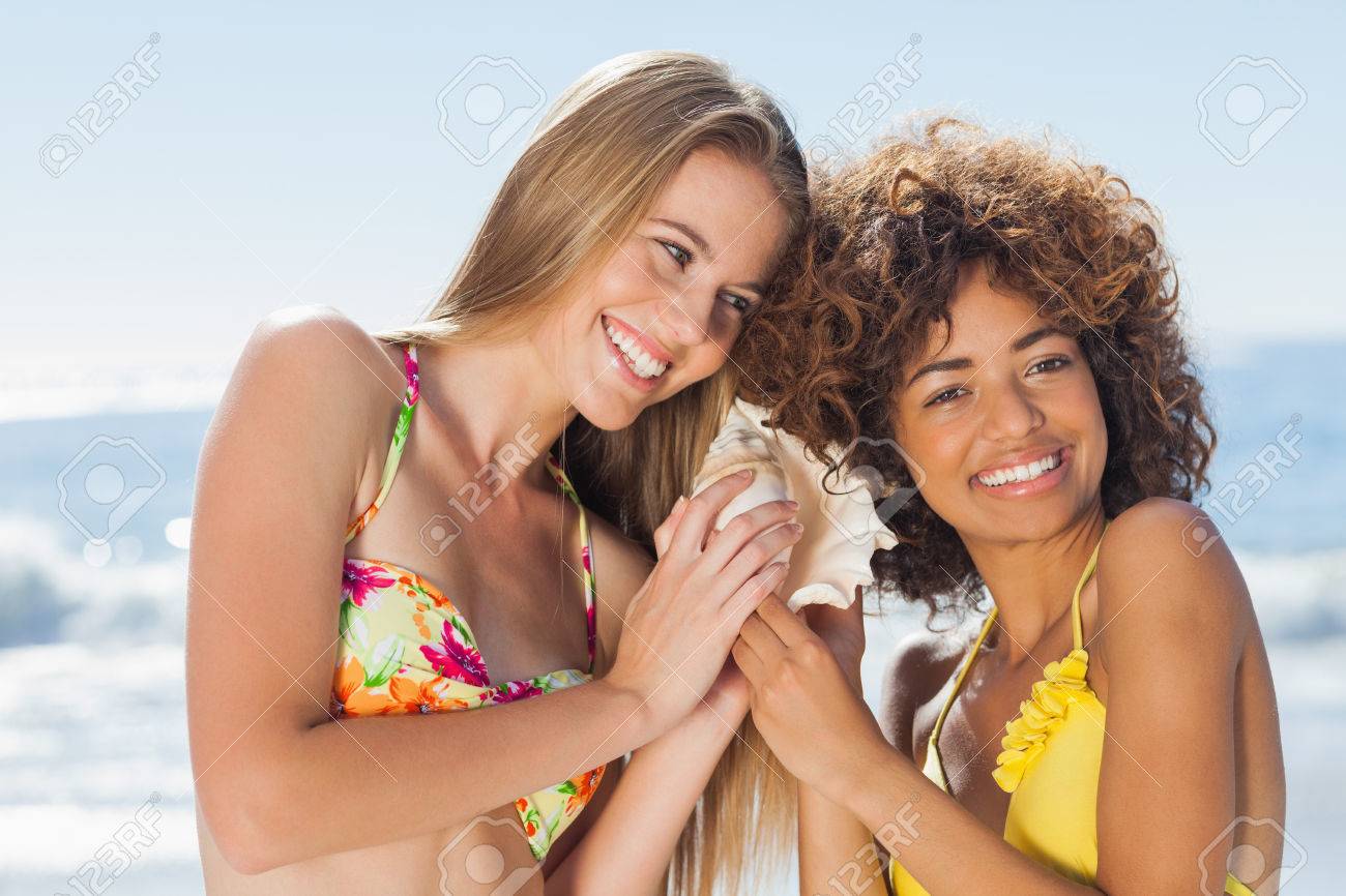 ビキニ ビーチにほら貝を聞いて 2 人の女の子 の写真素材 画像素材 Image
