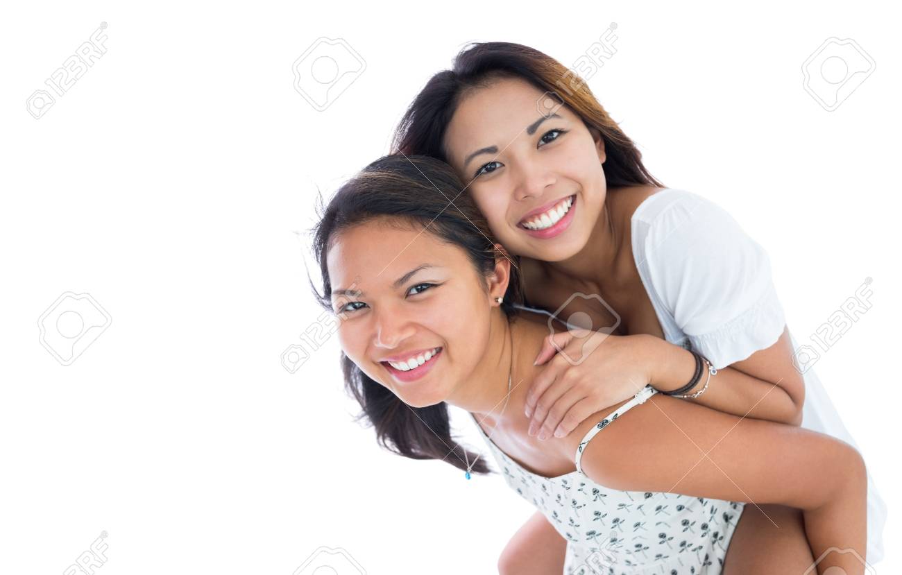 白い背景におんぶ彼女の妹を与えること幸せな女 の写真素材 画像素材 Image