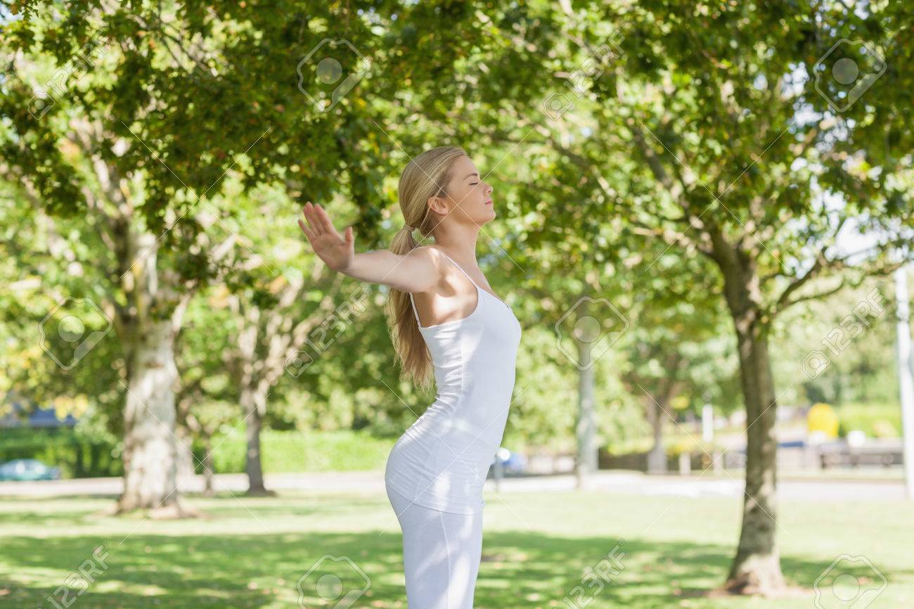 公園で両手を広げるポーズをやって素敵なフィット女性のプロフィール の写真素材 画像素材 Image