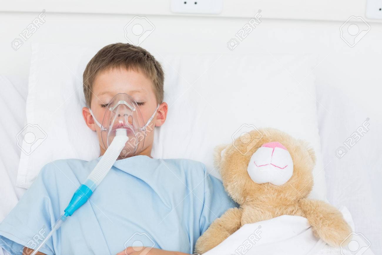 病気の少年は病院のベッドでぬいぐるみの横に眠っている酸素マスクの着用 の写真素材 画像素材 Image