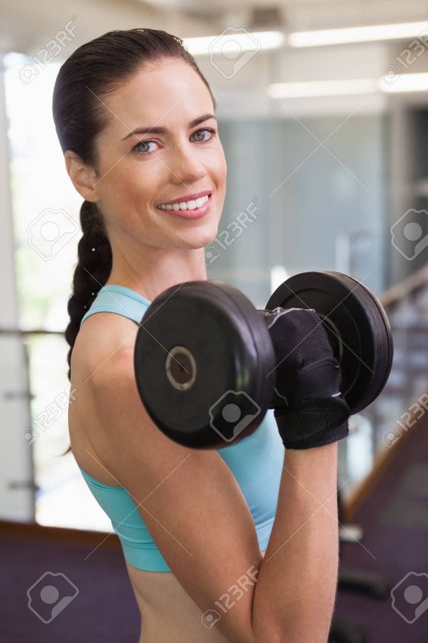 ジムで女性持ち上がる重いダンベルを笑顔 の写真素材 画像素材 Image