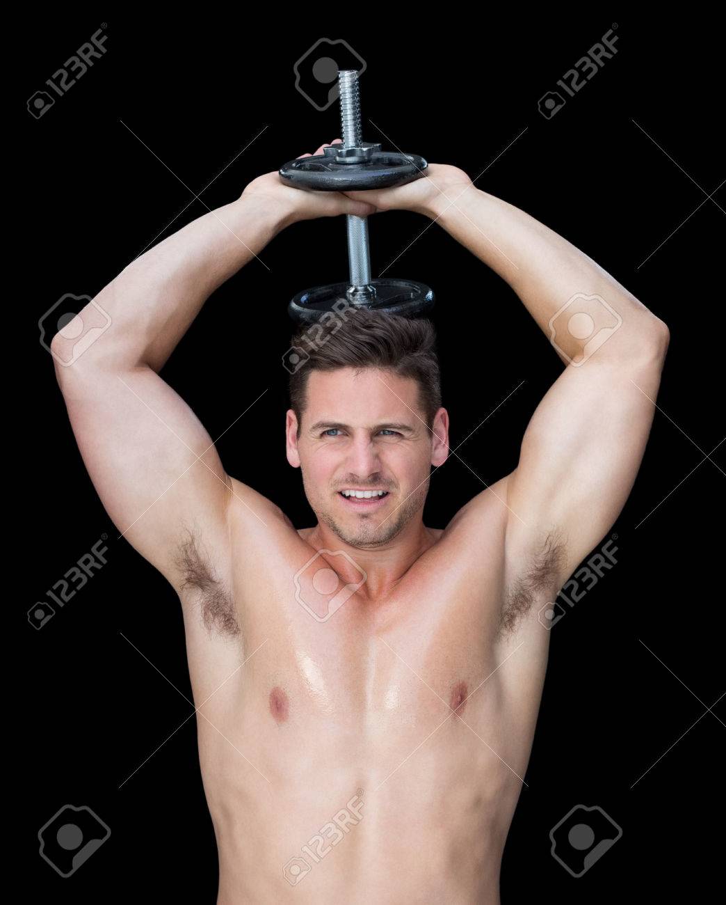 黒い背景に頭の後ろに重い黒いダンベルを持ち上げる強い Crossfitter の写真素材 画像素材 Image