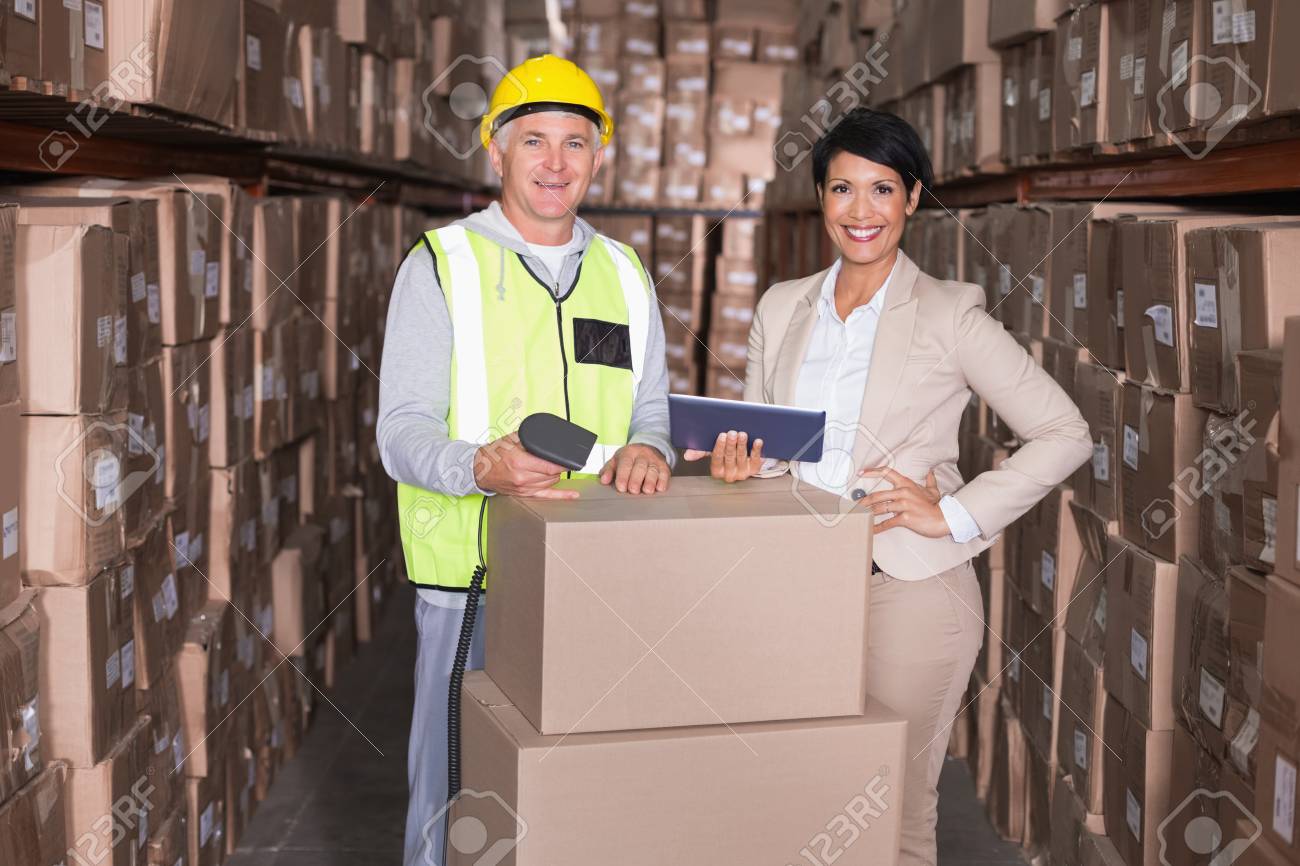 大規模な倉庫でタブレット Pc を持ってマネージャー ボックスをスキャン倉庫作業員 の写真素材 画像素材 Image