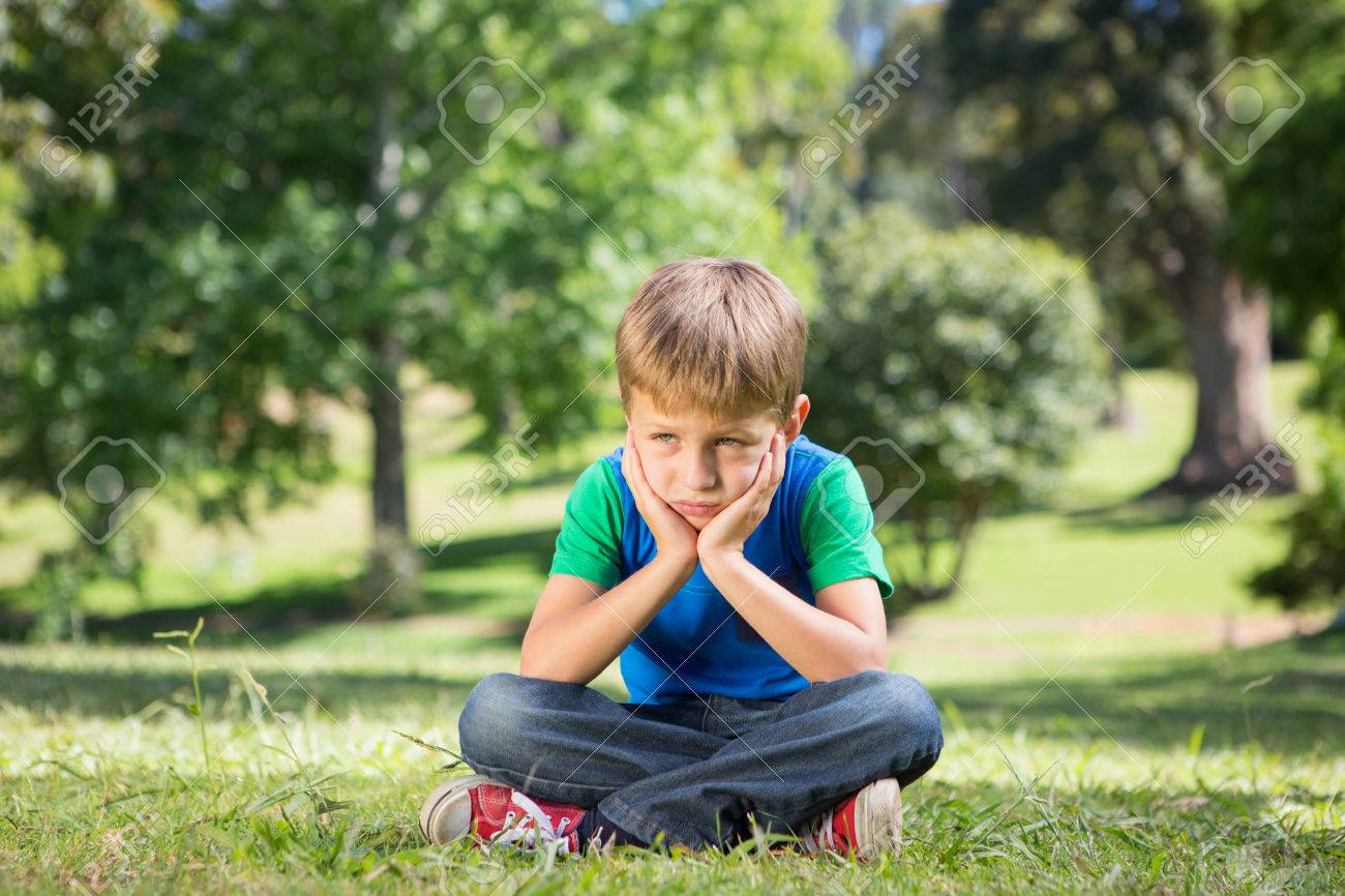 Little Boy Feeling Sad In The Park On A Sunny Day Stock Photo ...