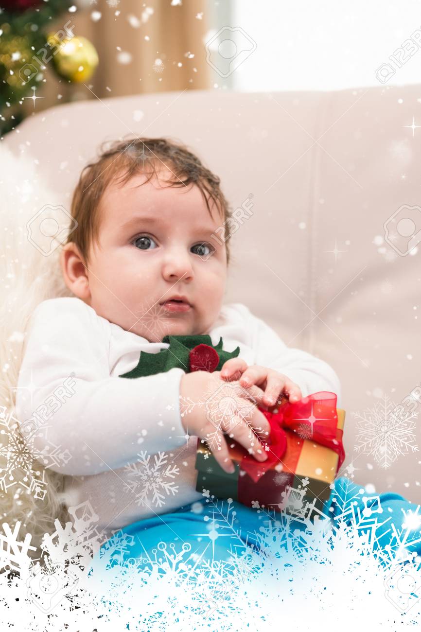 Cute Baby Boy On The Couch At Christmas Against Snow Falling Stock