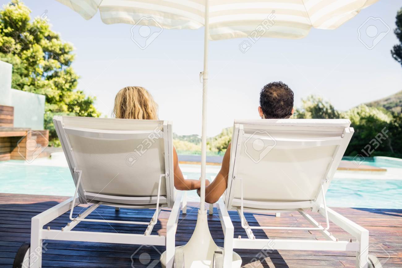 プールサイドのデッキチェアでカップルの後姿 の写真素材 画像素材 Image