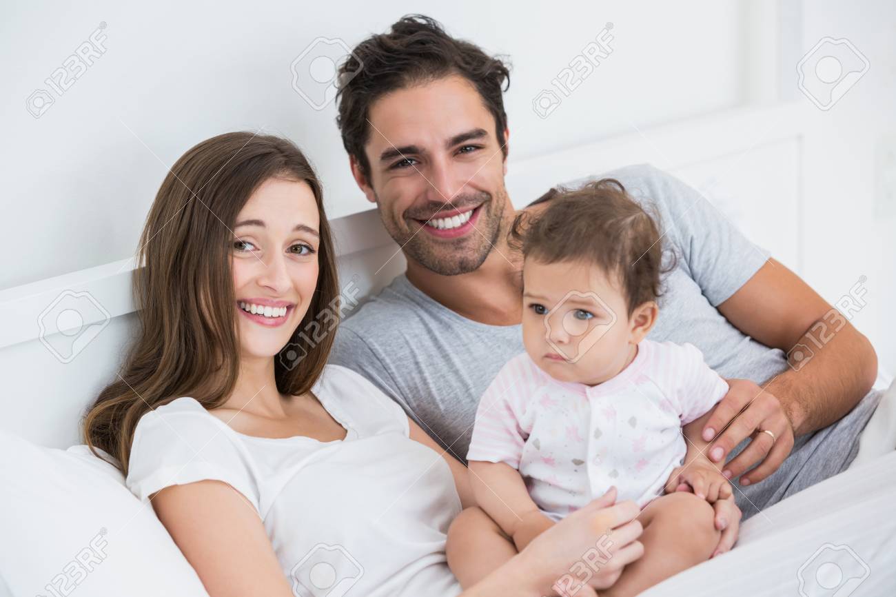 Portrait De Couple Heureux Avec Bebe Fille Reposant Sur Le Lit A La Maison Banque D Images Et Photos Libres De Droits Image