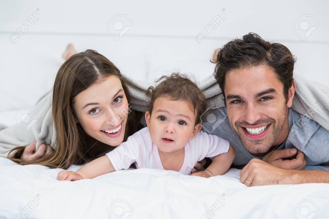 Portrait D Un Couple Heureux Avec Bebe Couche Sur Le Lit A La Maison Banque D Images Et Photos Libres De Droits Image