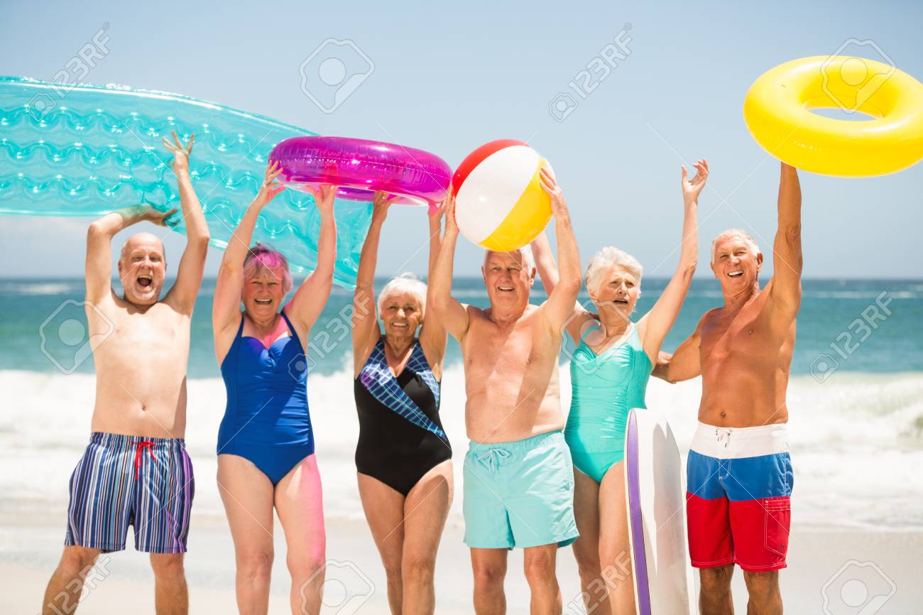 Seniors Standing In A Row At The Beach On A Sunny Day