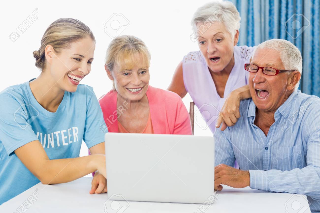 stock photo volunteer and seniors using a laptop in a retirement home