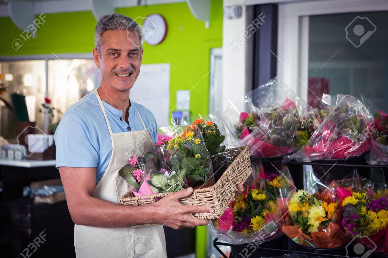 彼のフラワー ショップで籐のかごで植木鉢を運ぶ男性の花屋の肖像画 の写真素材 画像素材 Image