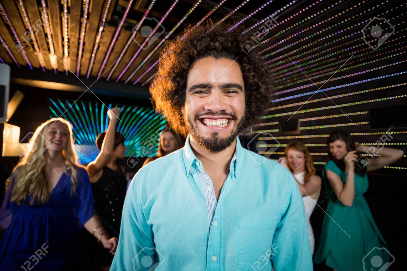 Portrait Of Smiling Man Standing In Dance Floor While Friends