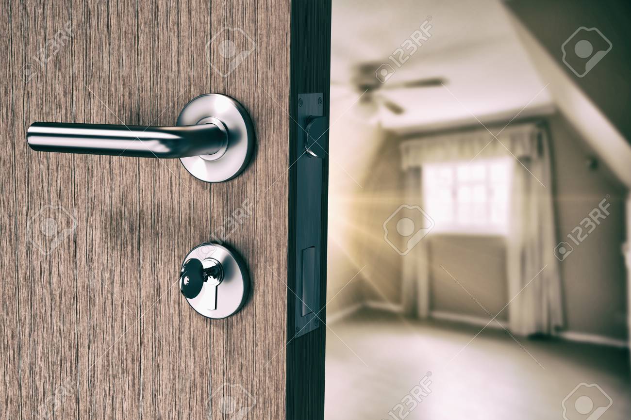 Brown Door With Doorknob And Key Against Empty Master Bedroom