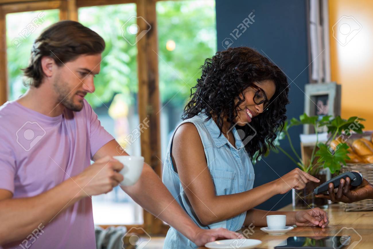 カフェのカウンターでクレジット カード リーダーの Pin コードに入る女 の写真素材 画像素材 Image