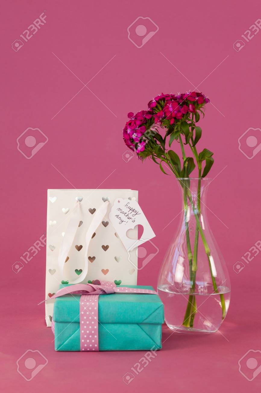 gift box paper bag and flowers vase on pink background stock photo paper bag flower vase