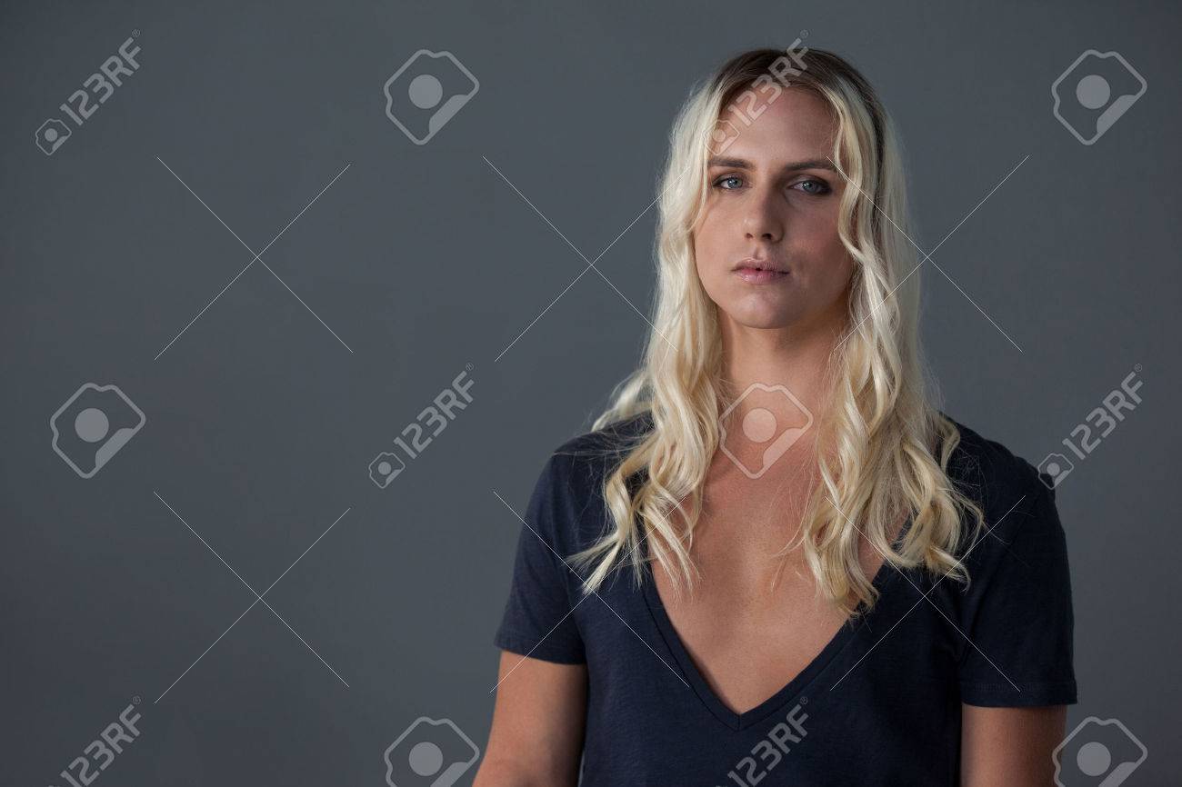 Portrait of woman with blond hair standing over gray background - 76068726 Portrait of woman with blond hair standing over gray background - 76068726