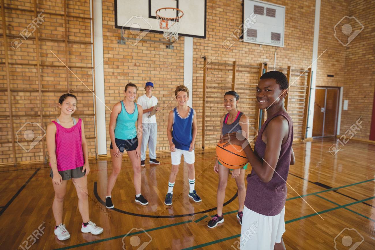 Portrait Of High School Kids Playing Basketball In The Court Stock