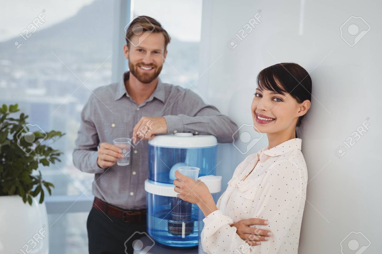 Portrait of smiling executives holding glasses of water in office - 77602370 Portrait of smiling executives holding glasses of water in office - 77602370