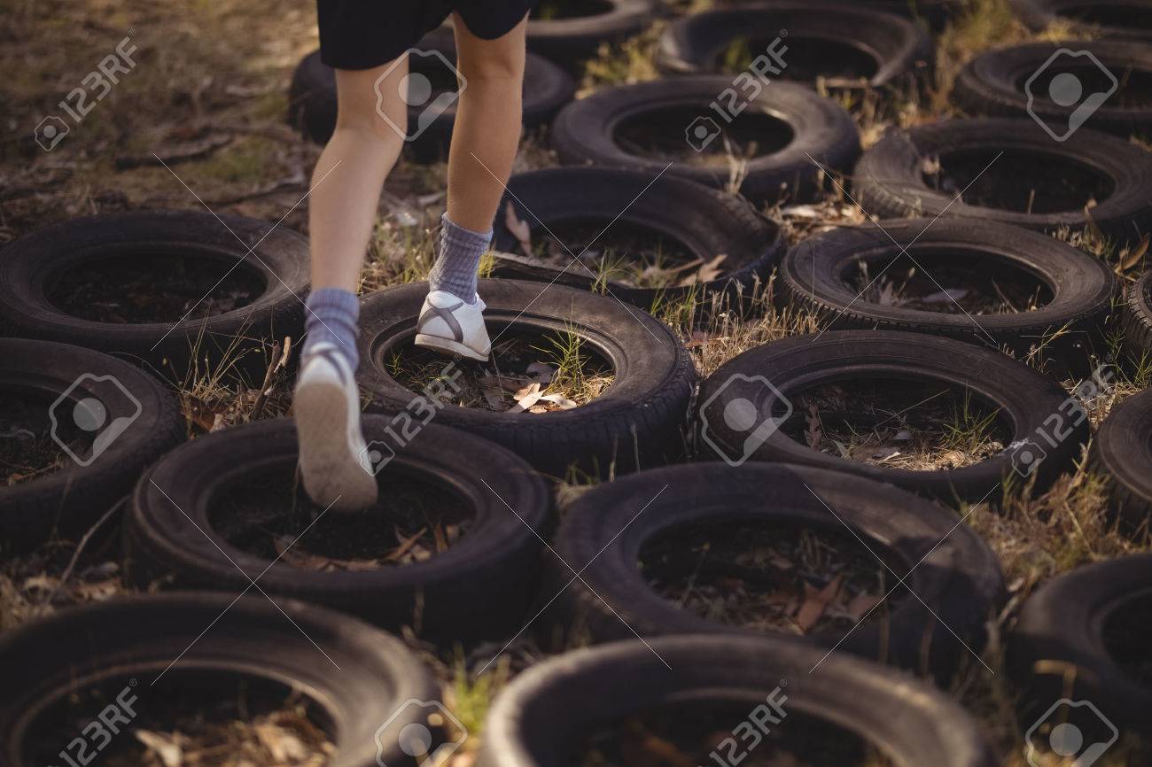 Low section of girl running over tyres during obstacle course - 79252442 Low section of girl running over tyres during obstacle course - 79252442
