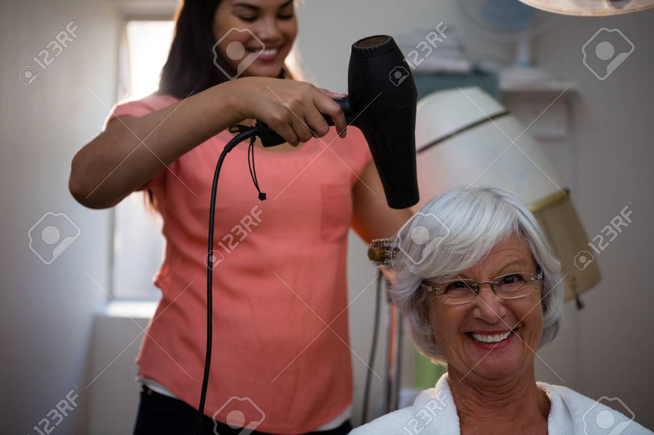 Beautician drying senior woman hair in salon - 83562514 Beautician drying senior woman hair in salon - 83562514