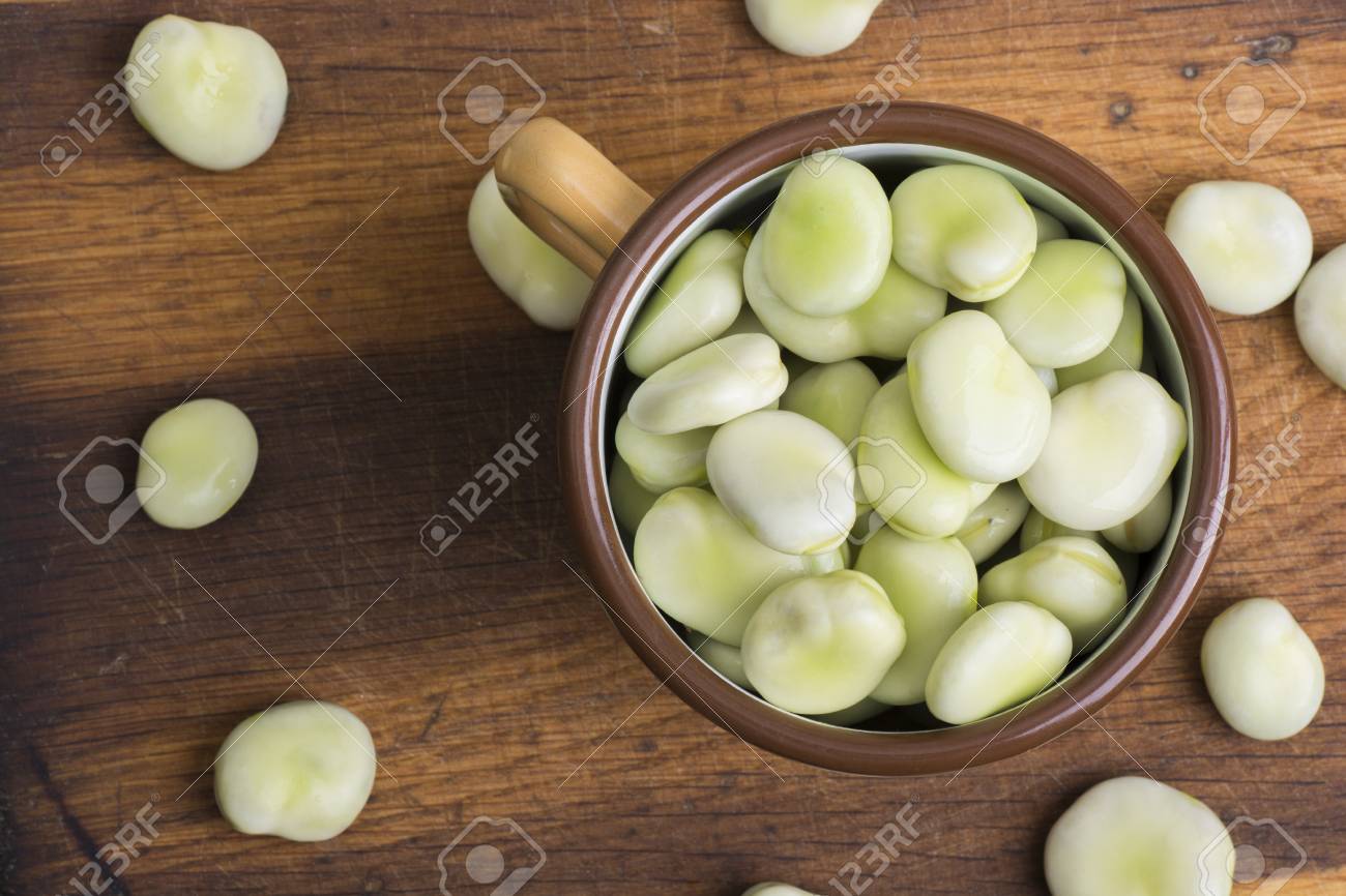 Fresh broad beans in bowl on wooden board - 60697574 Fresh broad beans in bowl on wooden board - 60697574