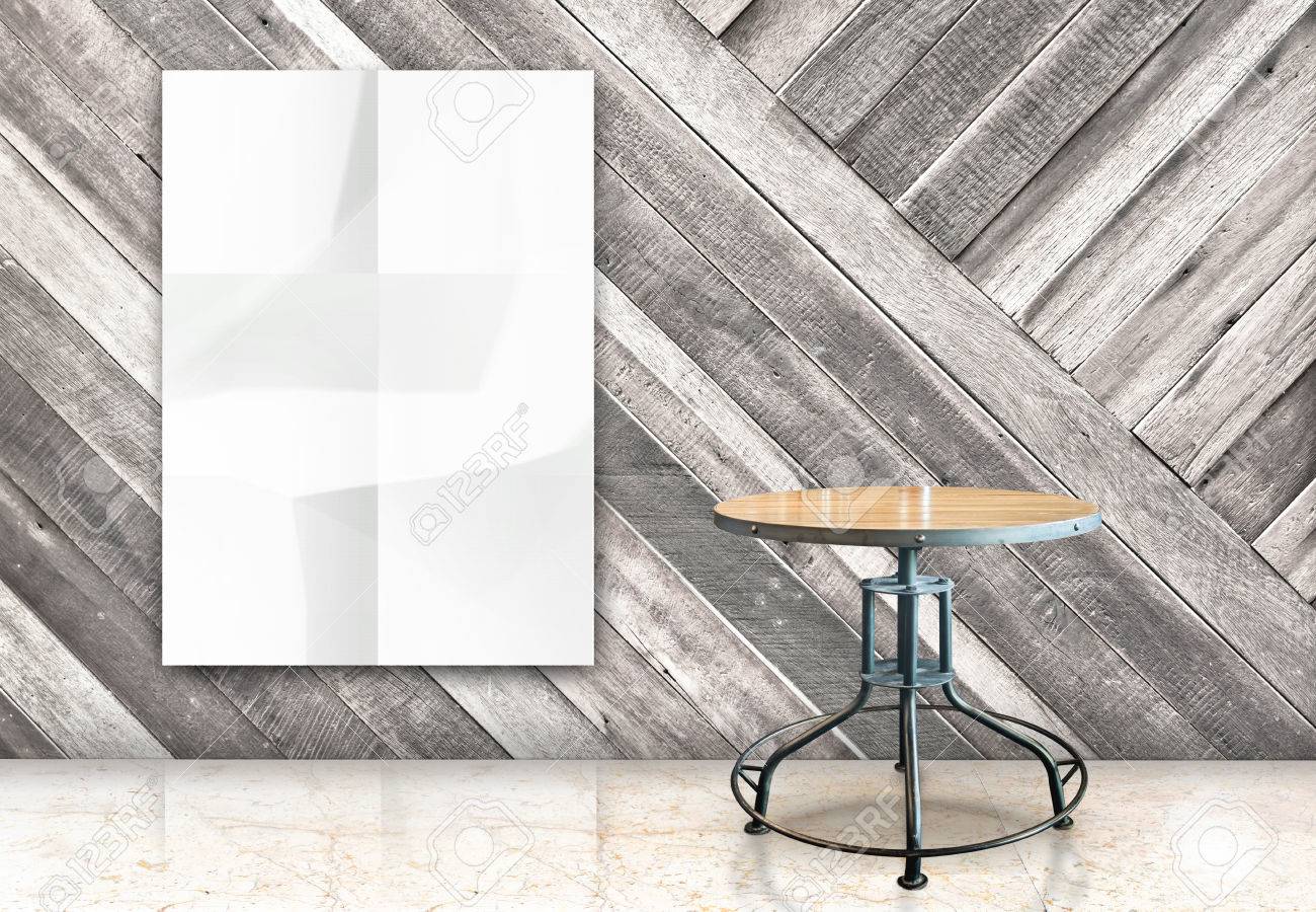 ぶら下げ空白しわくちゃ白ポスター 斜め壁 大理石の床の部屋 テンプレートがあなたの内容のために模擬で木製のテーブルの部屋 の写真素材 画像素材 Image