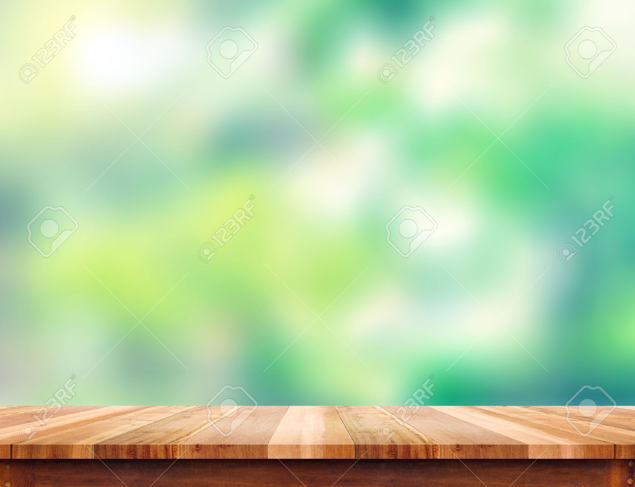 empty plank brown wood table top with blur green tree background