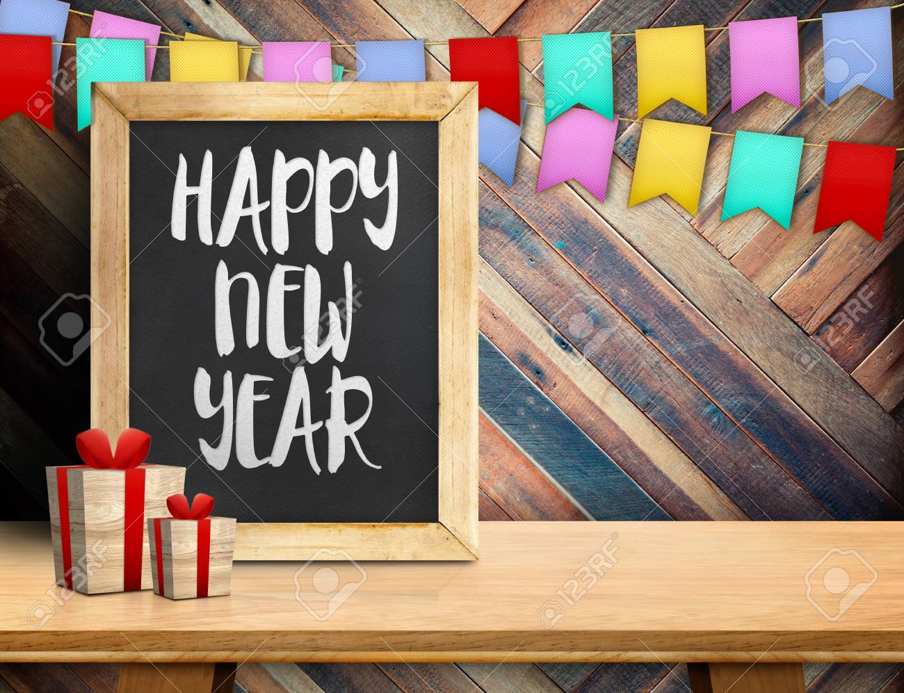 happy new year on blackboard with gift and colorful flag banner
