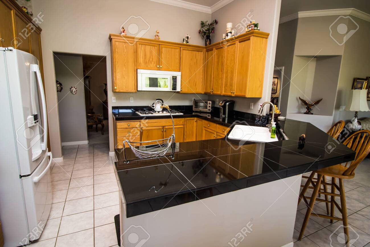 Kitchen With Wood Grain Cabinets And Granite Counter Bar Stock Photo Picture And Royalty Free Image Image 136107955