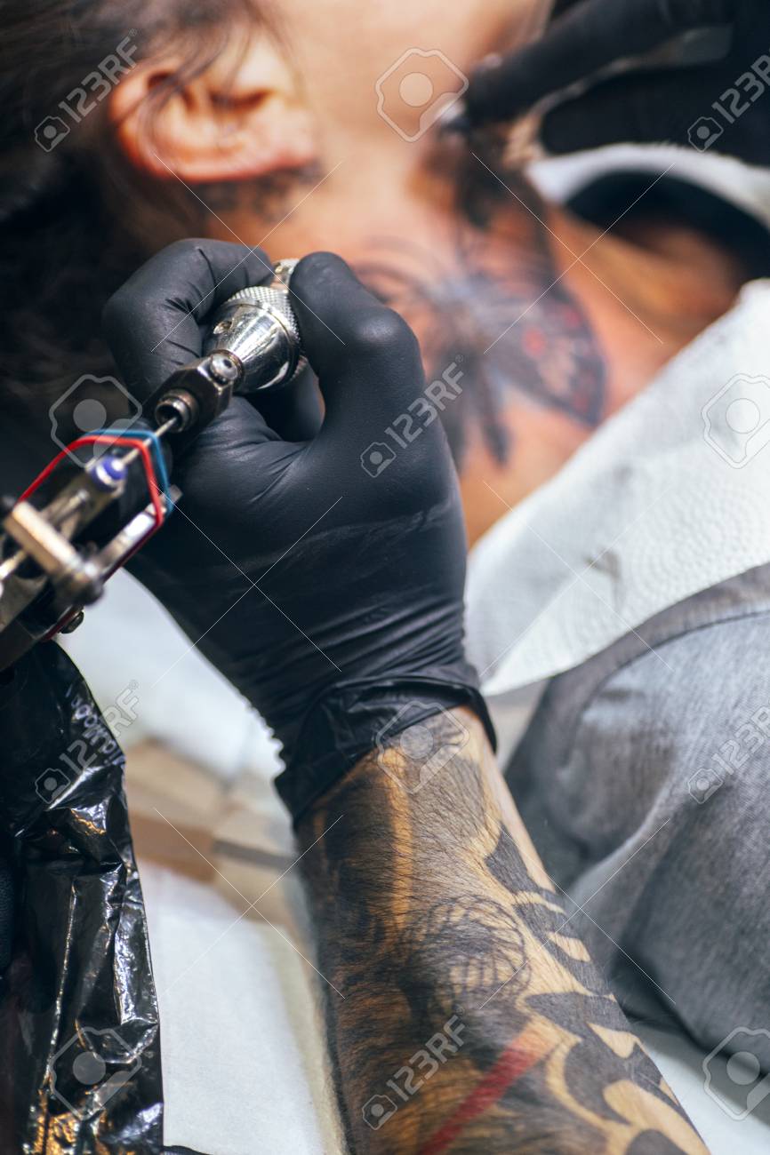 Femme Recevant Le Tatouage De Papillon à Son Cou