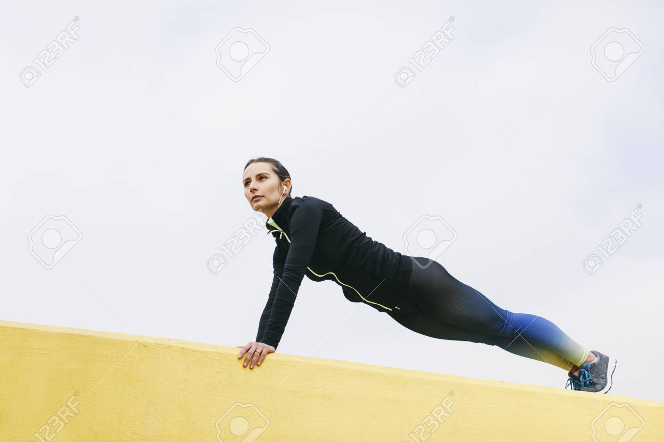 Spain Barcelona Female Jogger On Yellow Wall Pushup Stock Photo